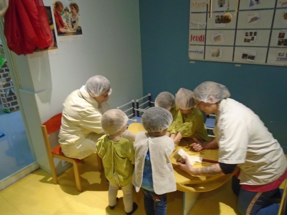 Enfants autour d'une petite table préparant une galette 